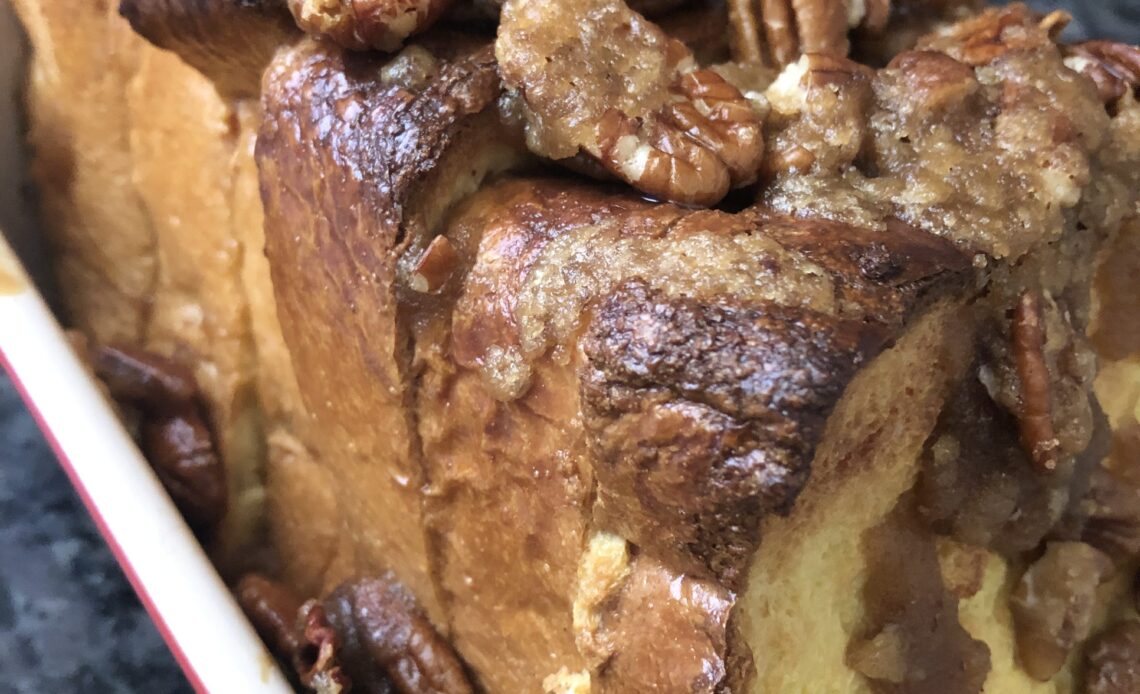 Egg Nog French Toast in a baking pan topped with candied walnuts