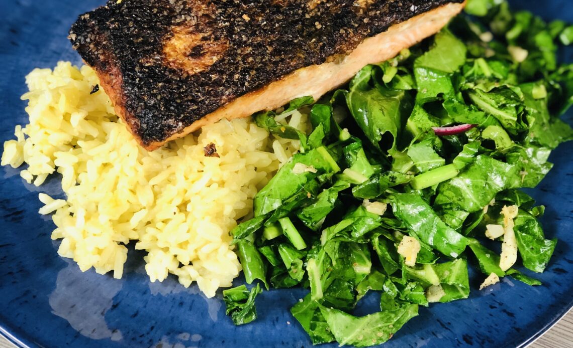 Crispy skin salmon served on a bed of rice pilaf with a side of sauteed kohlrabi