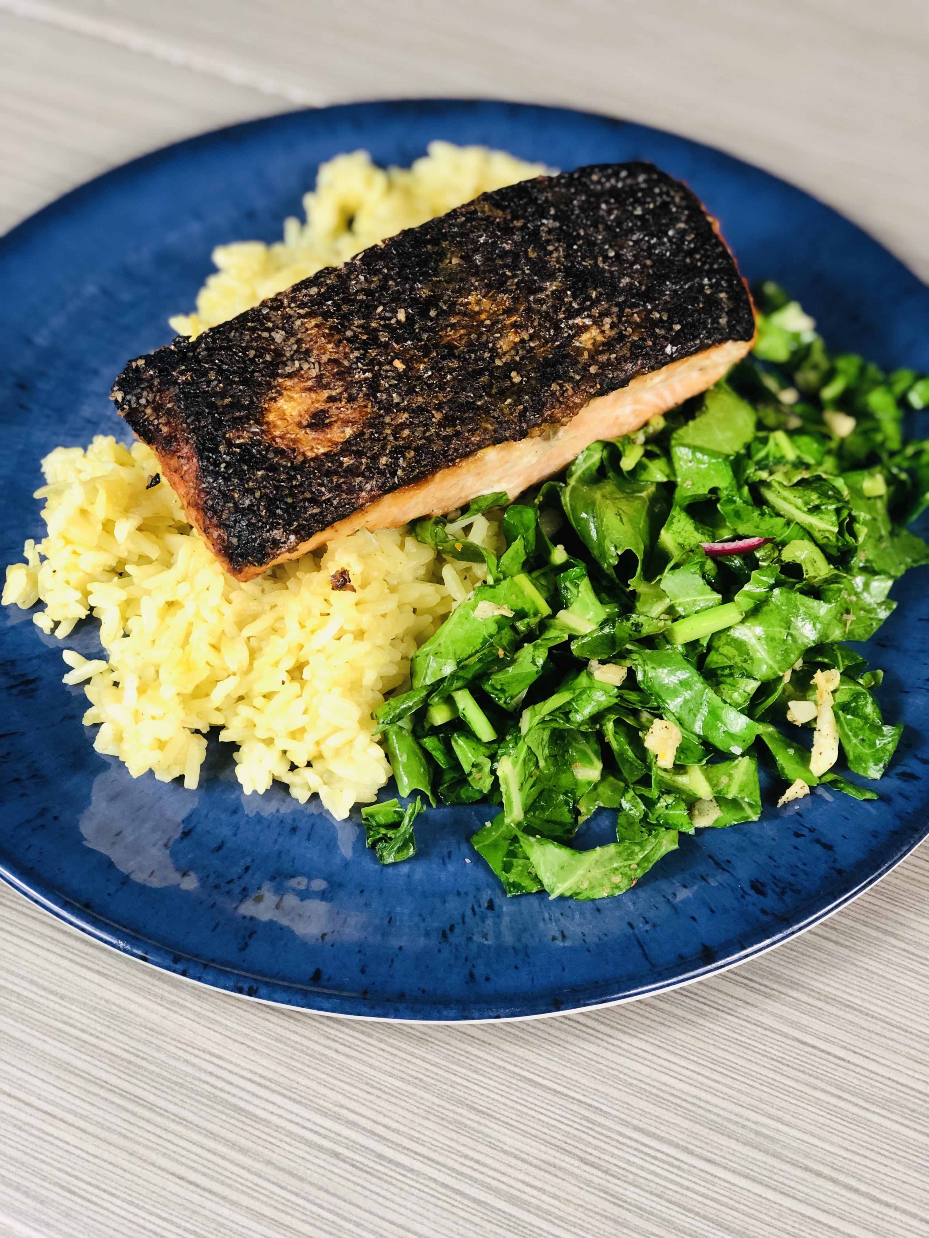 Crispy skin salmon served on a bed of rice pilaf with a side of sauteed kohlrabi