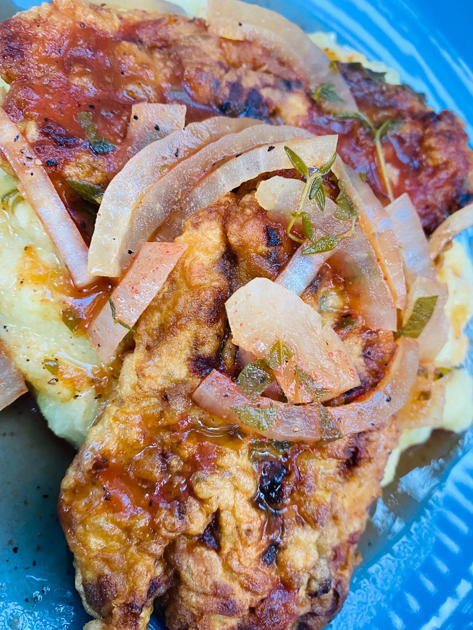 Coucou and Flying Fish smothered in Tomato Gravy served on a blue plate